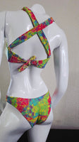 Colorful tie-dye bikini top on a mannequin against a neutral background