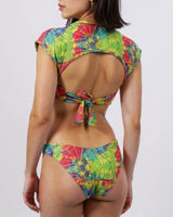 Woman wearing a colorful tie-dye bikini on a white background