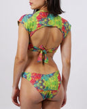 Woman wearing a colorful tie-dye bikini on a white background