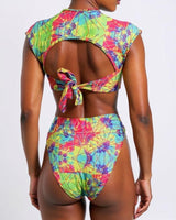 Person wearing a colorful tie-dye bikini set on a white background