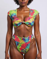 Woman wearing a colorful bikini against a plain background
