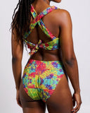 Woman wearing a colorful tie-dye bikini against a white background