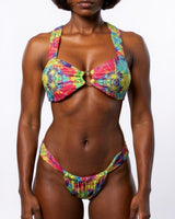 Woman wearing a colorful tie-dye bikini against a white background