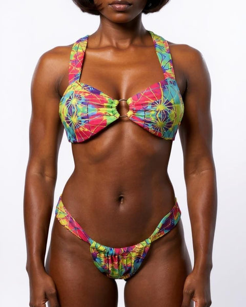 Woman wearing a colorful tie-dye bikini against a white background
