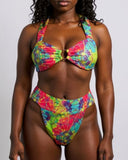 Woman wearing a colorful tie-dye bikini against a white background