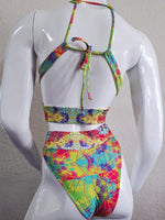Colorful tie-dye bikini set on a mannequin against a gray background